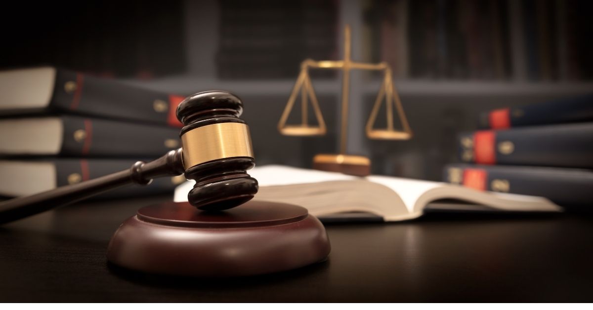 an image of a brown gavel in a courtroom.